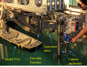 Photo showing model 5512 mounted to the PMM carriage with the towed, TPIV system in the foreground supported by the PMM carriage strongback.  The underwater camera enclosures and laser-sheet generator (all submerged) are visible in the image.